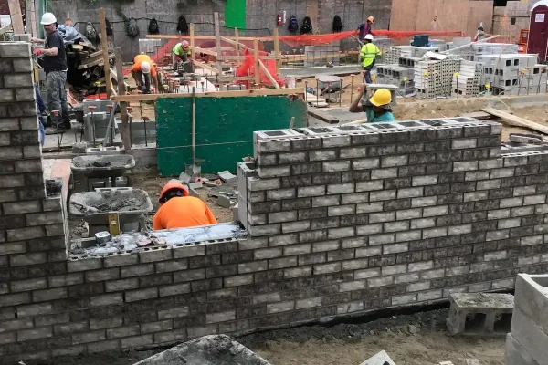 a-mason-applies-cement-to-a-brick-to-build-a-wall-2025-01-08-09-24-38-utc